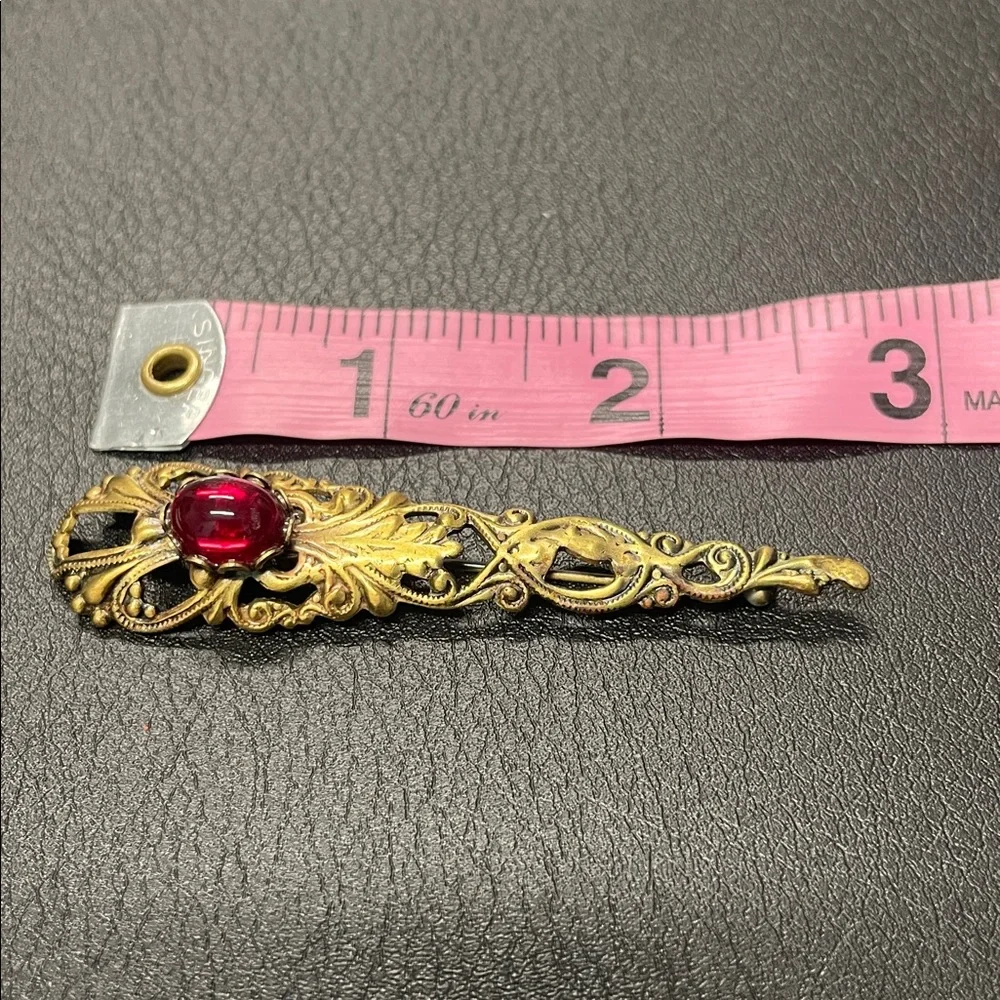 Filigree gold toned, brooch pin with red stone